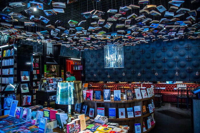 Interno di una grandiosa libreria con libri appesi al soffitto e comodi posti a sedere in un'atmosfera magica. Interno di una grandiosa libreria con libri appesi al soffitto e comodi posti a sedere in un'atmosfera magica.
