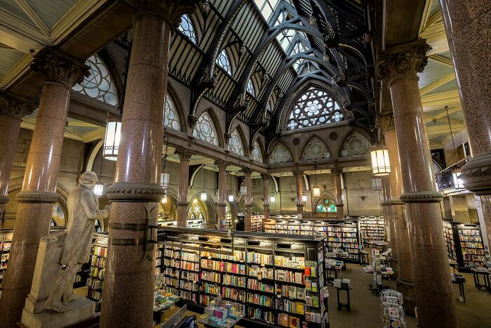 Grandiose library interior with towering columns, arched ceilings, and shelves filled with books in a magical setting. Grandiose library interior with towering columns, arched ceilings, and shelves filled with books in a magical setting.
